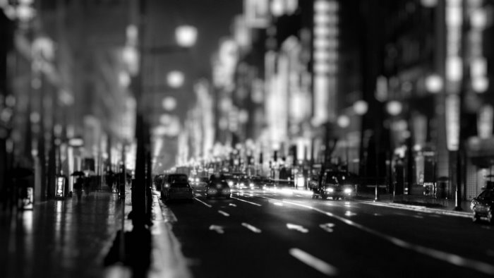 Monochrome street scene with cars and city lights