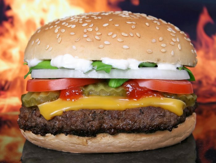 Hamburger with cheese, pickles, tomato, onion, and lettuce