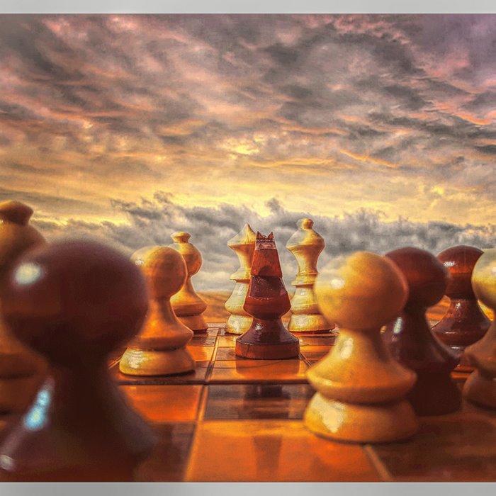 Chess pieces on a board with a dramatic sky
