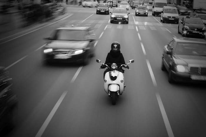 Motorcyclist and cars on a busy city street