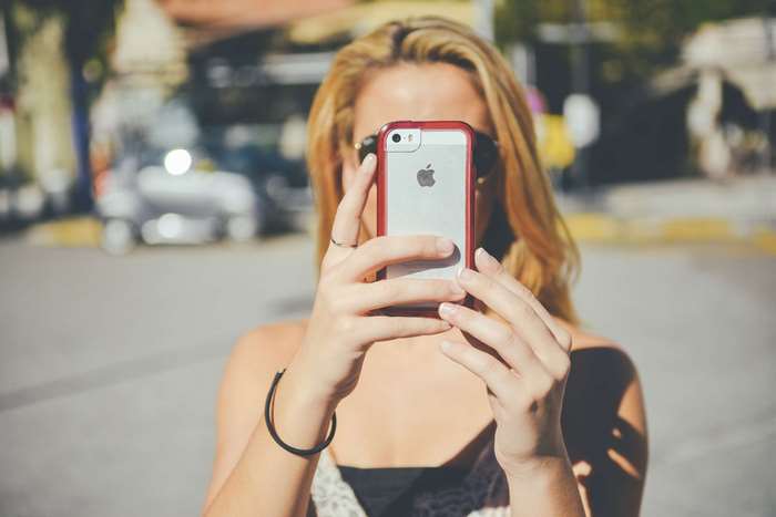 Woman taking a selfie with an iPhone