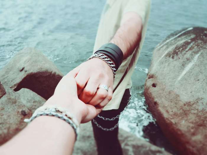 Couple holding hands by the water