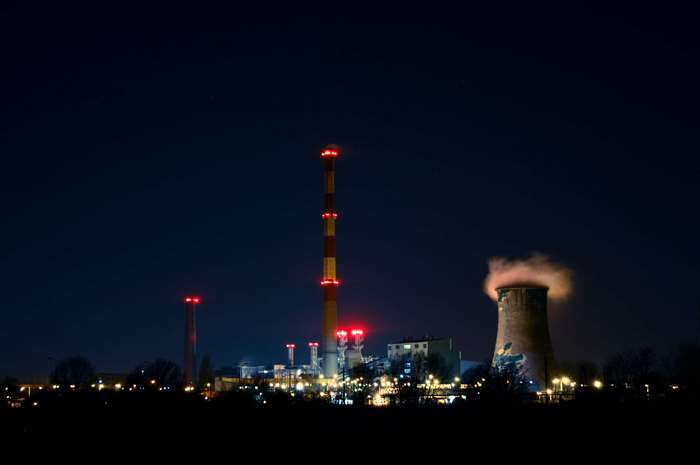 Industrial factory at night with smoking cooling tower