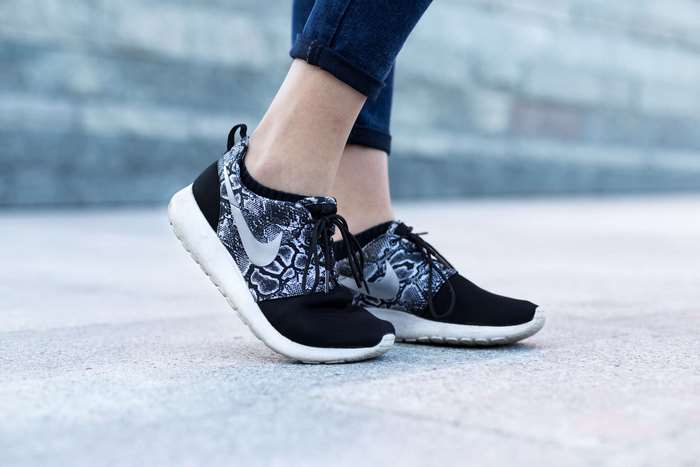 Woman wearing Nike Roshe sneakers with snake print