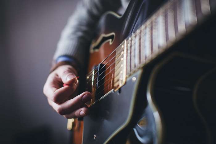 Close-up of a person playing an electric guitar