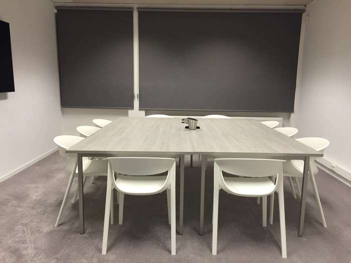 Modern meeting room with square table and white chairs