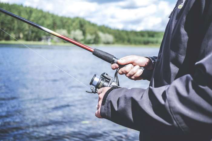 Man fishing with a rod and reel on a lake