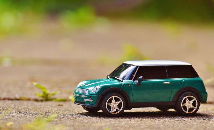 Green Mini Cooper toy car on pavement