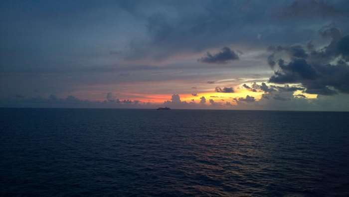 Cruise ship on the ocean at sunset 4K