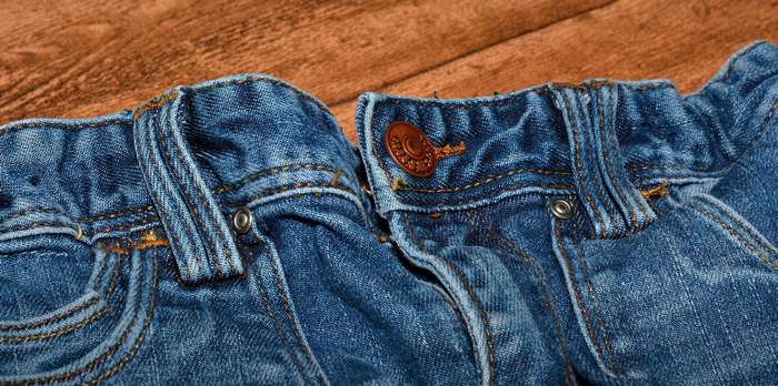 Close-up of blue denim jeans with copper button