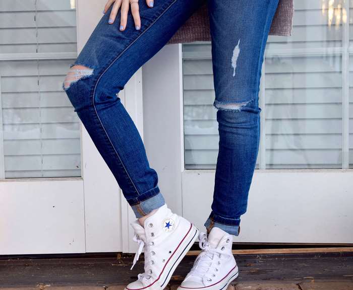 Woman wearing ripped jeans and Converse sneakers