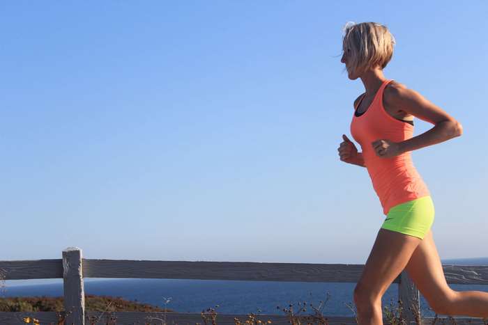 Woman jogging by the ocean 4K