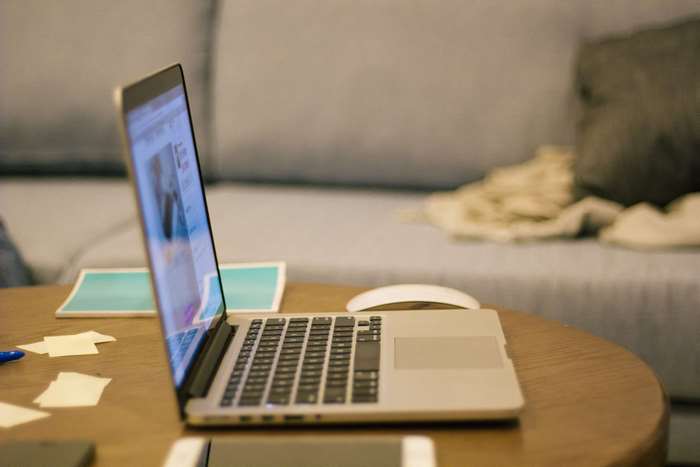 MacBook Pro on a wooden table with a mouse