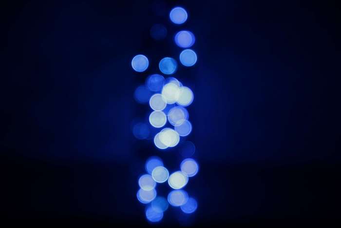 Blue and white bokeh lights on dark background