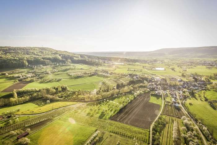 Aerial view of a rural village and countryside with sunglare