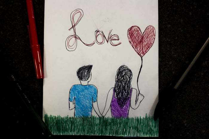 Drawing of a couple holding hands with a heart balloon