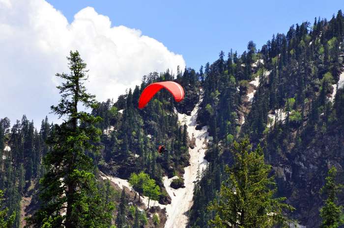 Paragliding over a snowy mountain in Himachal, India