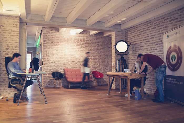Coworking office with people working and a TalentTree banner