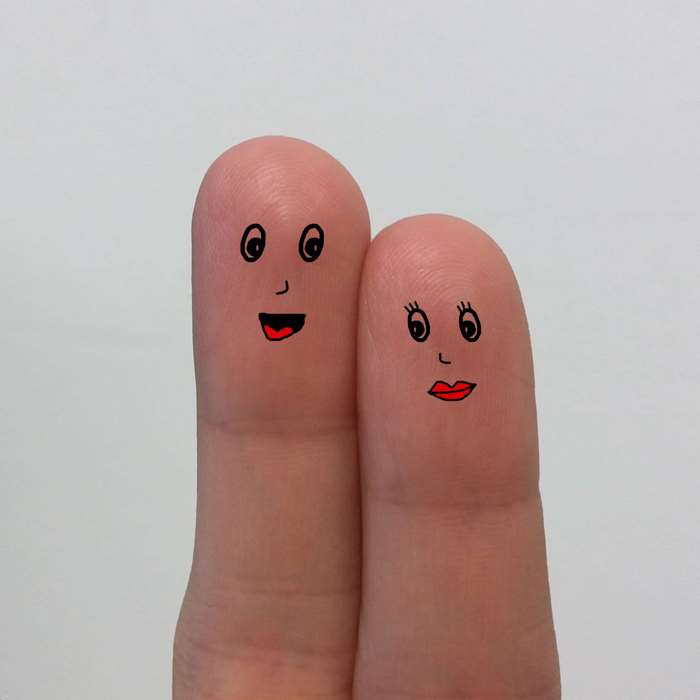 Two fingers with drawn faces