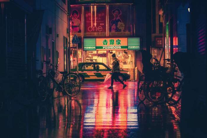 Person walking in a rainy Japanese street at night