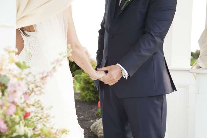 Bride and groom holding hands on wedding day 4K