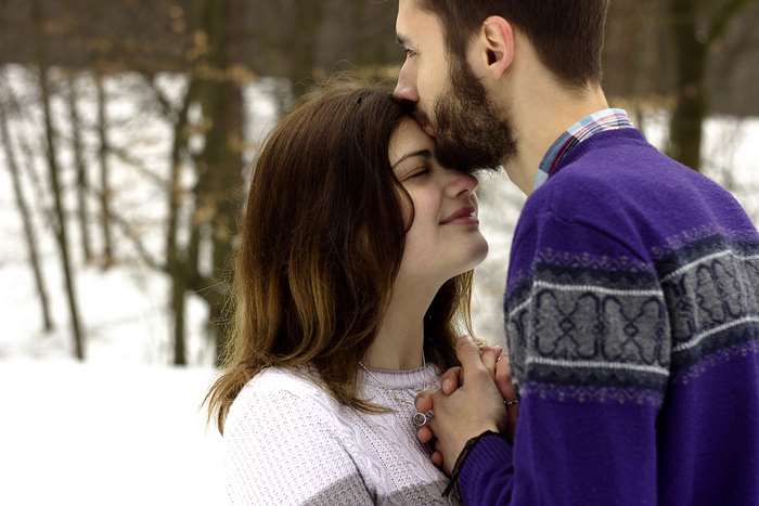 Couple kissing in the snow during winter