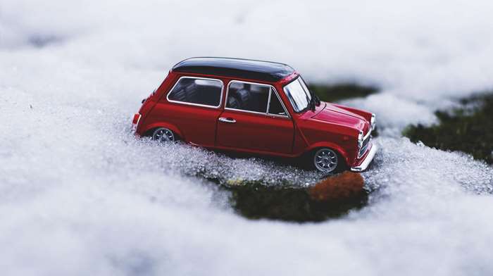 Red Mini Cooper toy car in snow