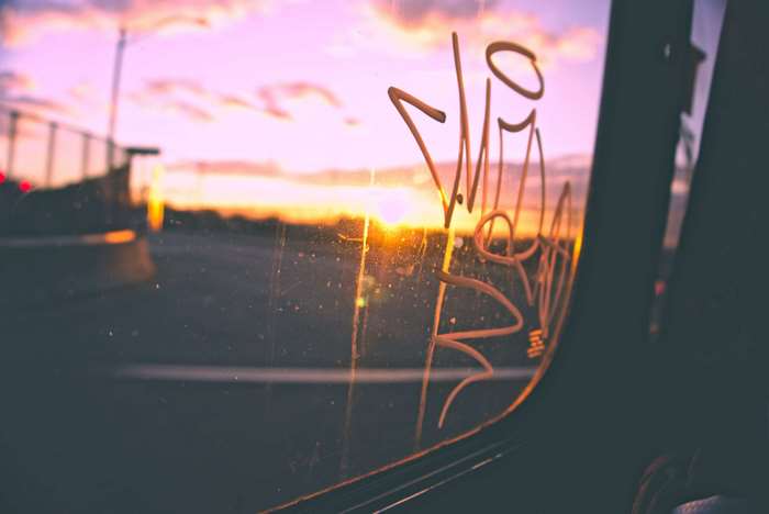 Graffiti on a bus window at sunset