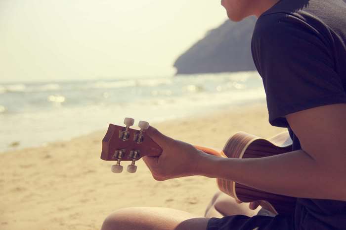 Man playing ukulele on the beach