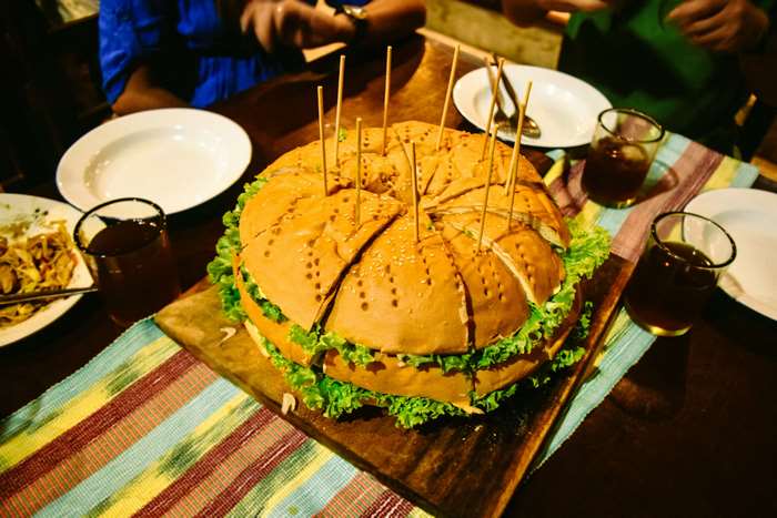 Giant burger cut into slices with toothpicks