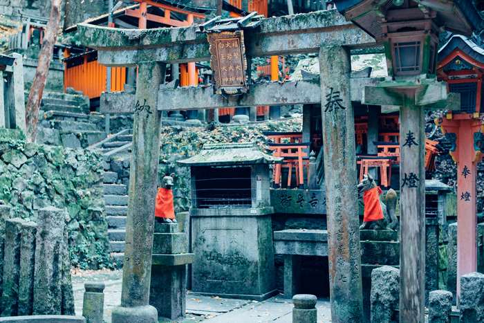 Stone Torii gates and fox statues at Fushimi Inari Shrine, Kyoto