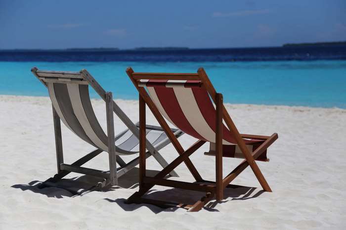 Beach chairs on a sandy beach with turquoise ocean