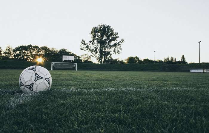 Soccer ball on a field at sunset