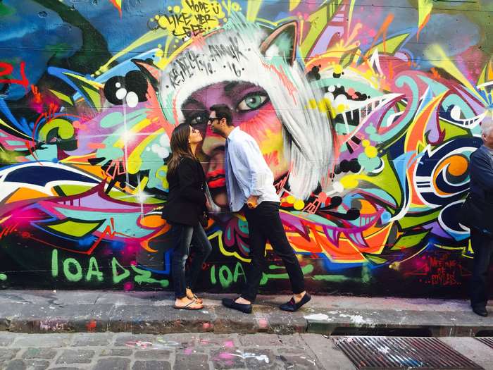 Couple kissing in front of graffiti art