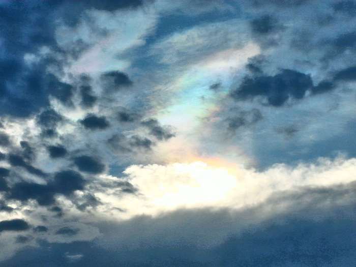 Rainbow in a cloudy blue sky