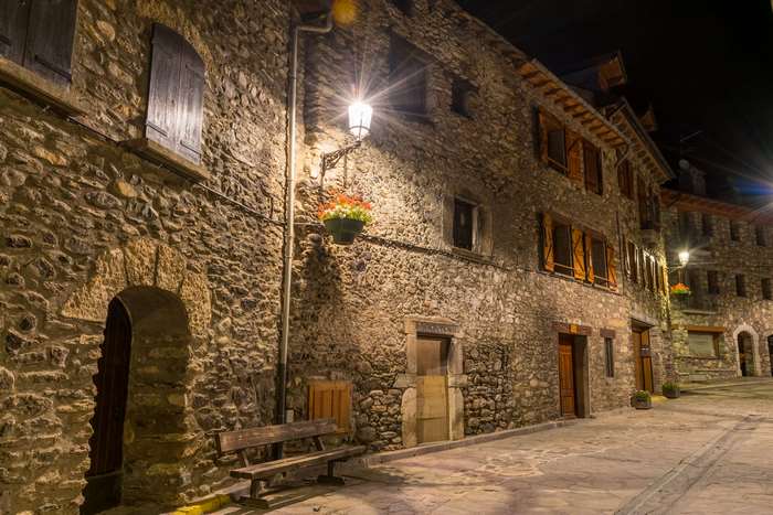 Stone alley with vintage street lights at night