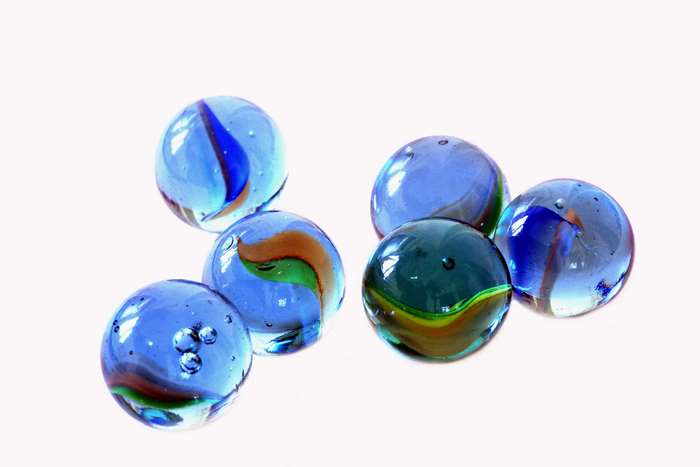 Six colorful glass marbles on a white background
