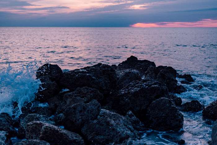 Ocean waves crashing on rocks at sunset 4K