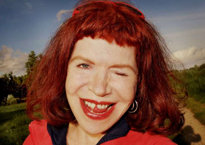 Woman with red hair winking and sticking out tongue