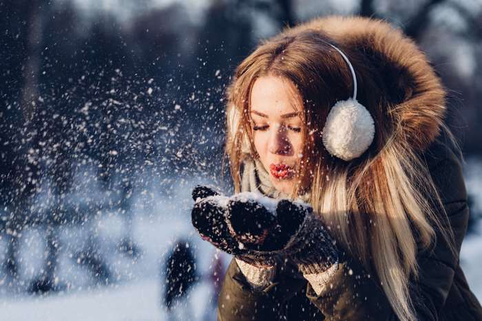 Young woman blowing snow in winter 4K