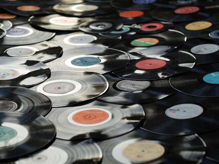 A large collection of vinyl records scattered.