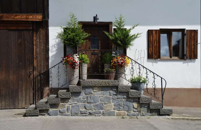 Rustic house entrance with stone stairs and flower pots