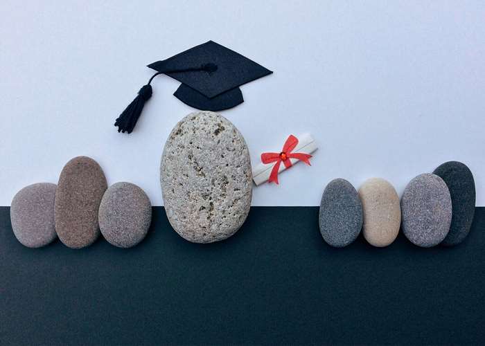 Graduation cap and diploma with stones