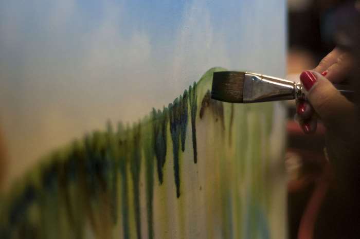 Woman painting abstract art with a paintbrush
