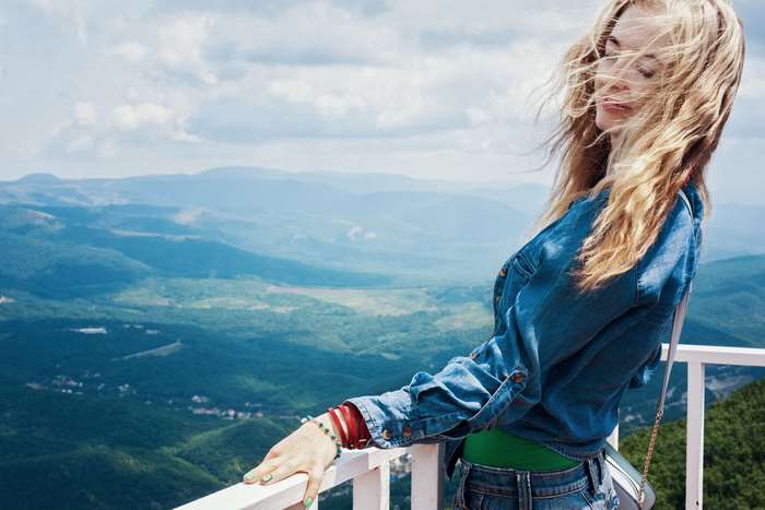 Young woman on a viewpoint overlooking mountains