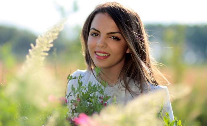 Pretty girl smiling in a field of flowers