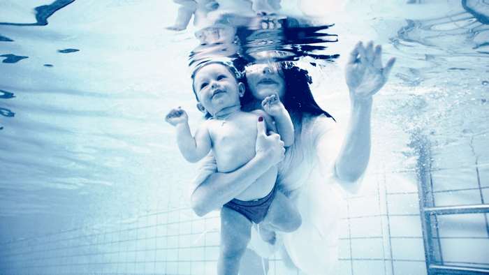 Woman and baby underwater in swimming pool