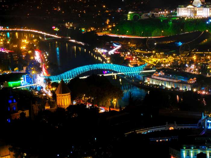 Tbilisi cityscape at night with illuminated bridges and buildings