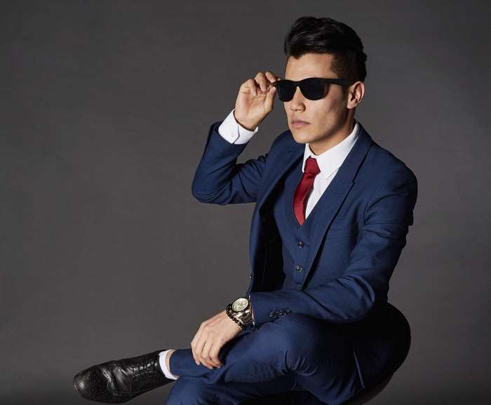 Man in a blue suit and sunglasses posing