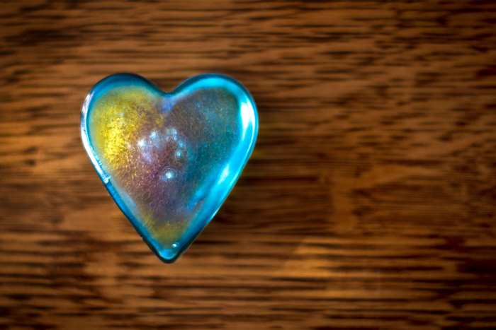 Blue glass heart on wood 4K